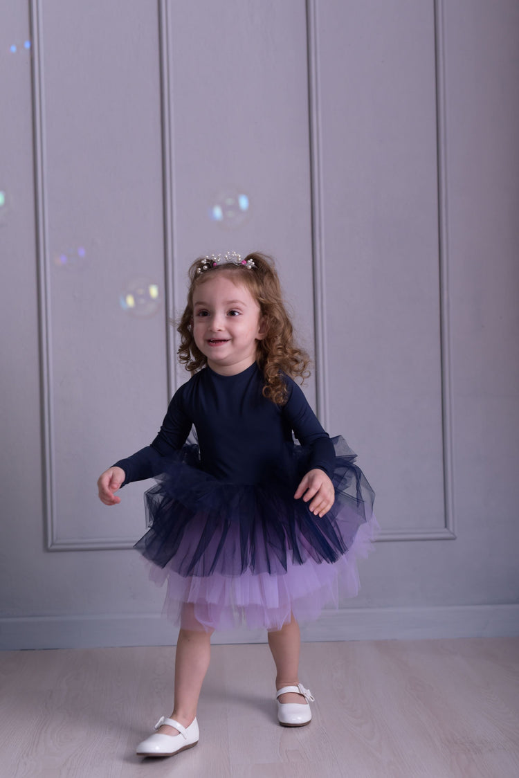 a little girl wearing a purple and blue dress