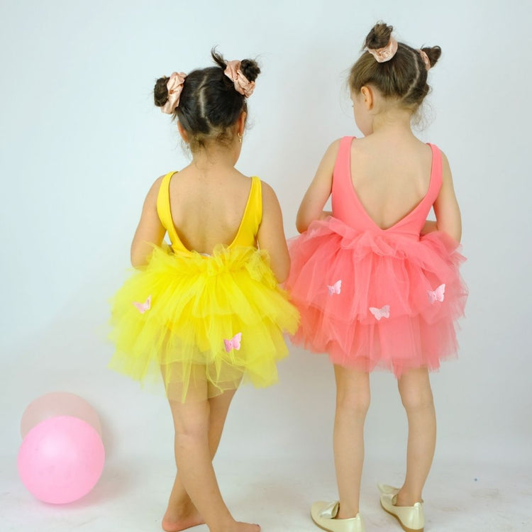 two little girls dressed in yellow and pink tutus