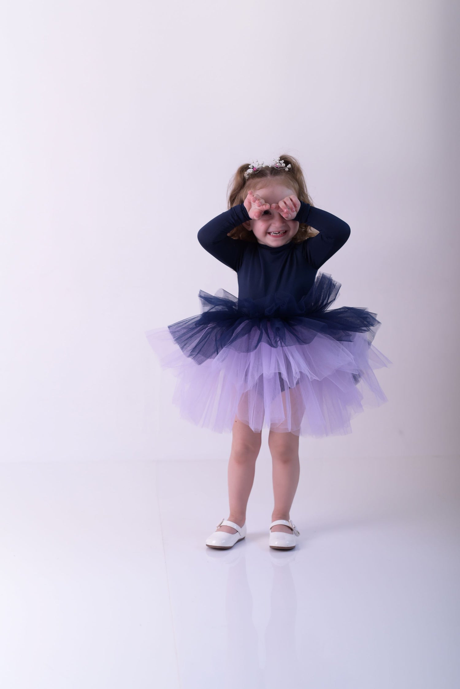 a little girl wearing a purple and blue dress