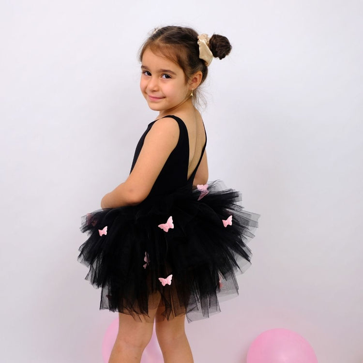 a little girl standing next to a pink ball