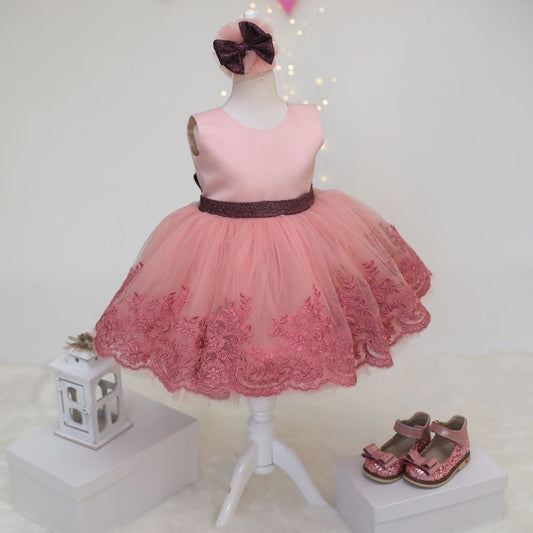 a little girl's pink dress and shoes on display