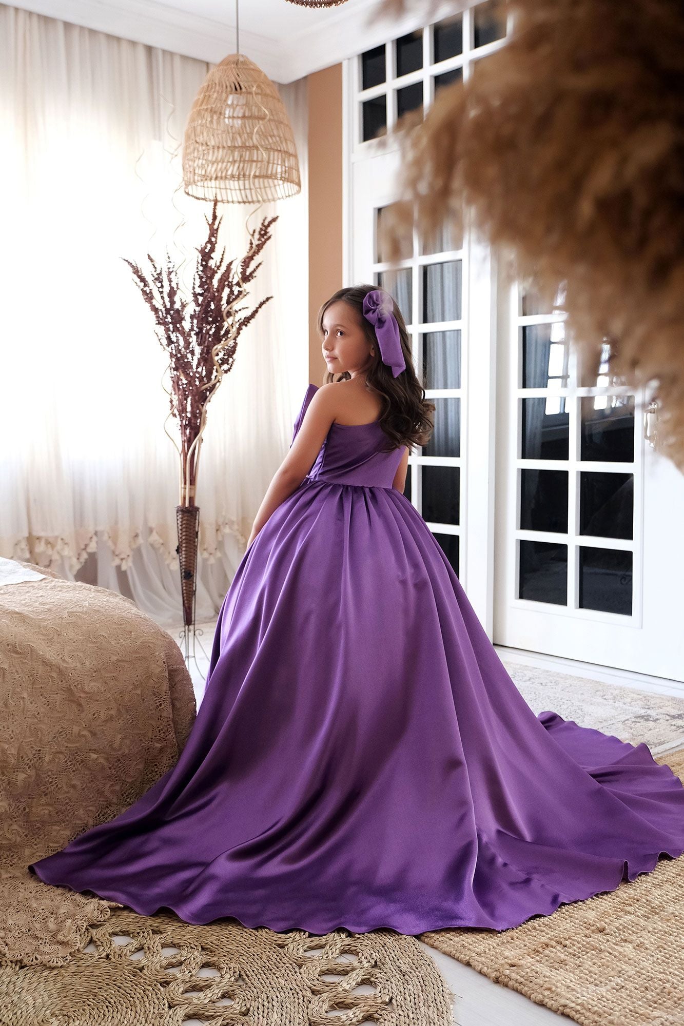 a woman in a purple dress sitting on a bed