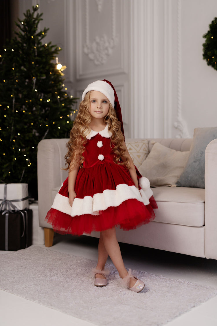 a little girl dressed in a red and white dress