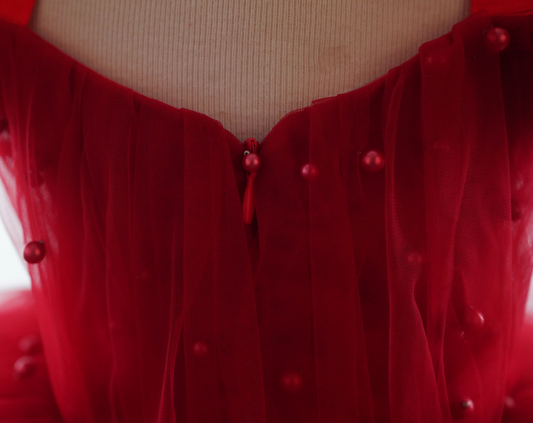 a woman's red dress is shown with buttons