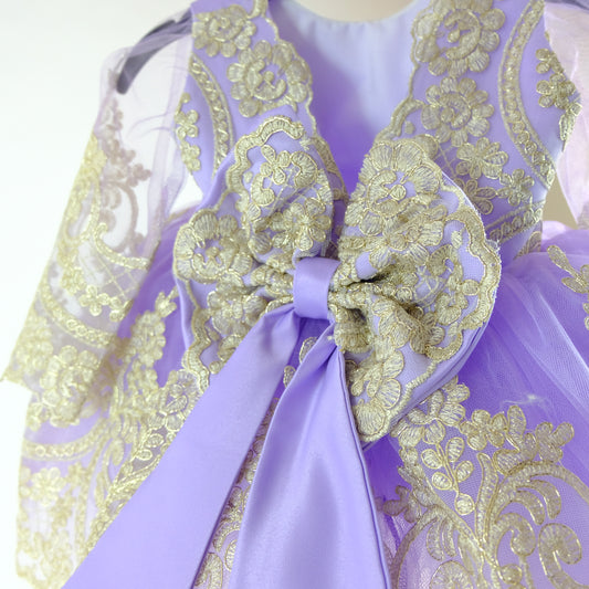 a purple and gold dress with a large bow