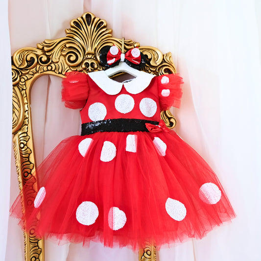 a red and white polka dot dress hanging on a wall