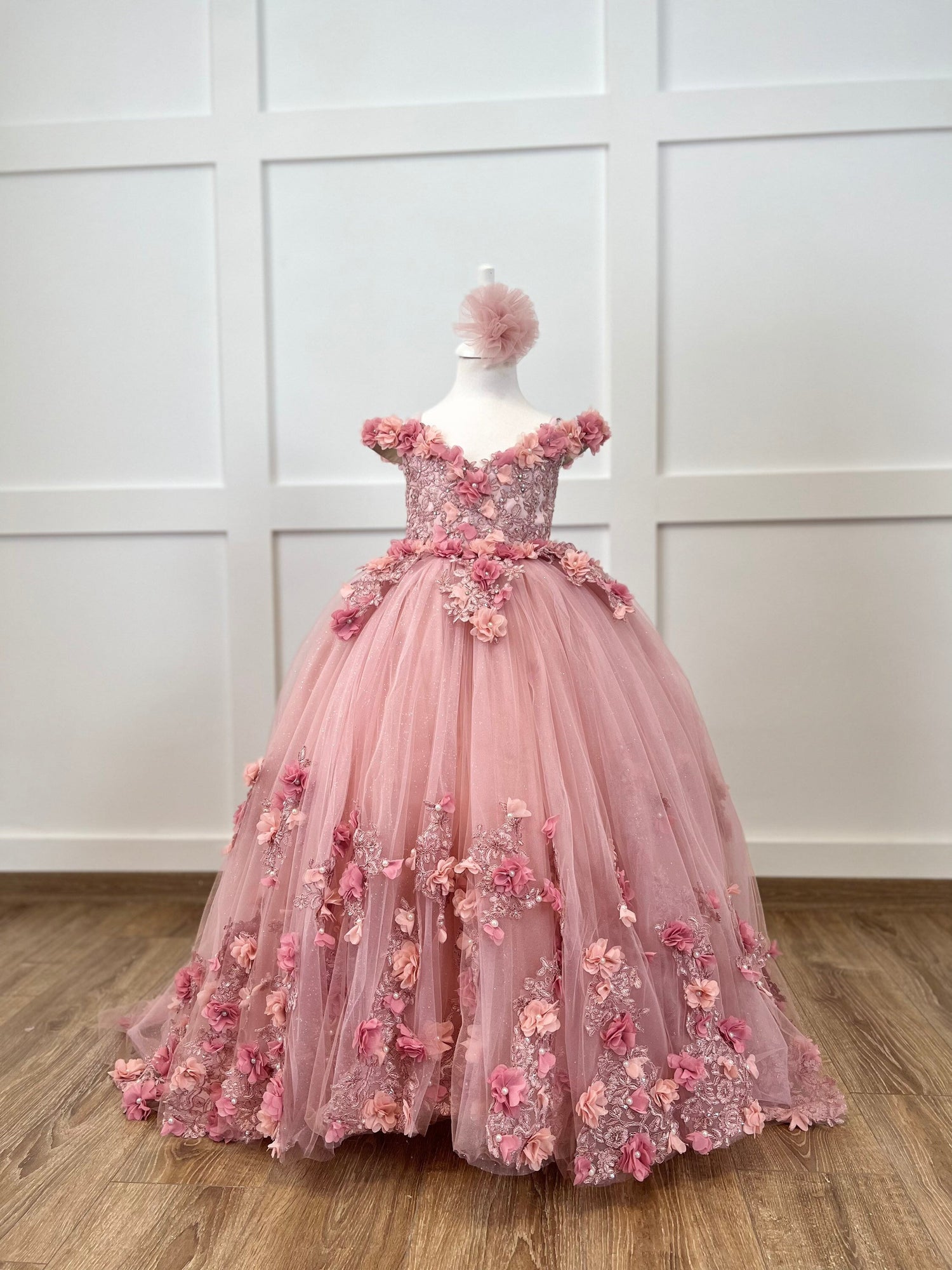 Delight in elegance with our satin and lace dress, featuring a bodice adorned with 3D colorful flowers and intricate details. The skirt boasts multiple layers of glittery tulle and lace, complemented by a soft cotton lining for comfort. Includes a matching gift hair accessory for the perfect finishing touch. Baby Girl Dress