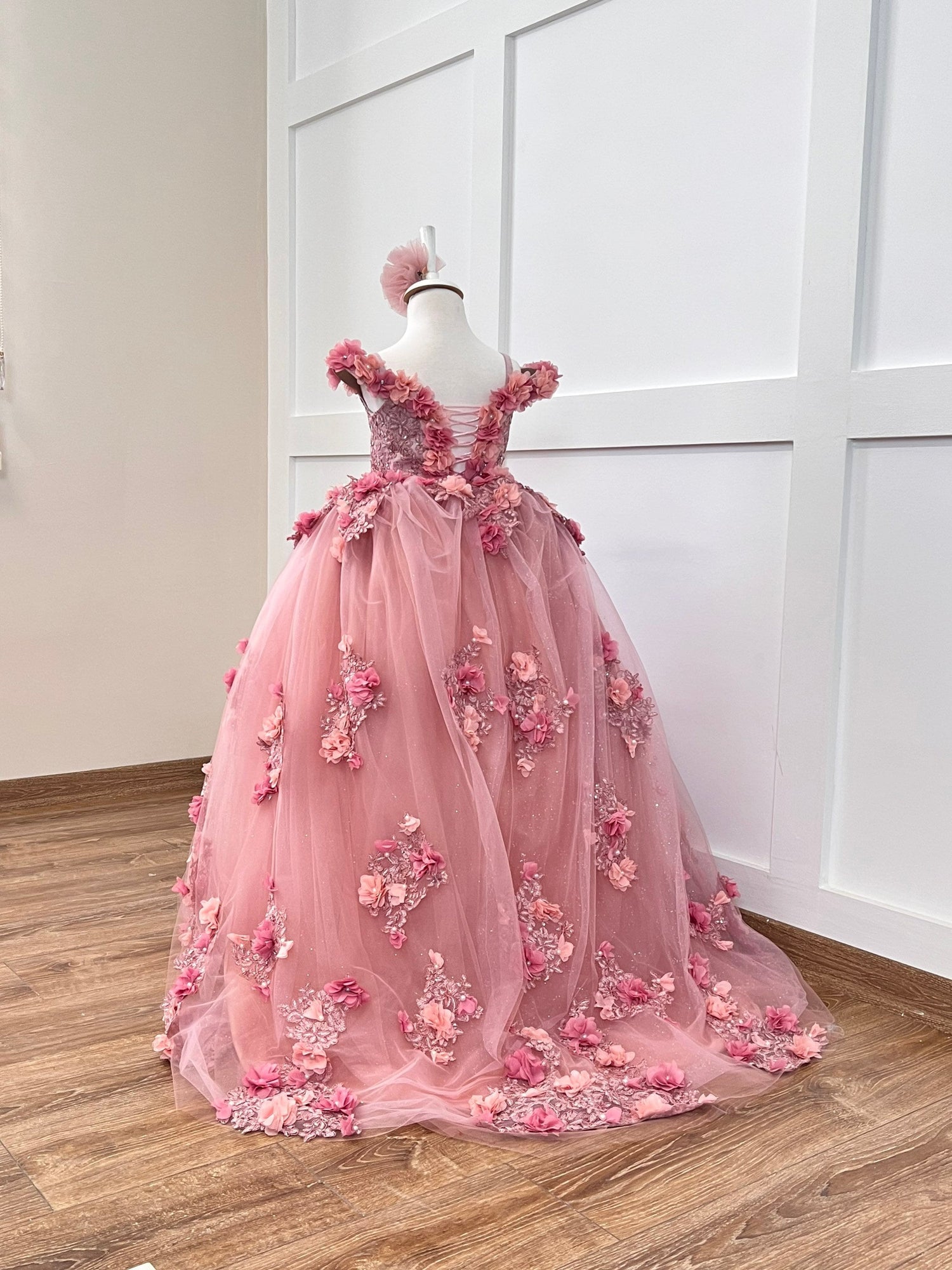 Delight in elegance with our satin and lace dress, featuring a bodice adorned with 3D colorful flowers and intricate details. The skirt boasts multiple layers of glittery tulle and lace, complemented by a soft cotton lining for comfort. Includes a matching gift hair accessory for the perfect finishing touch.