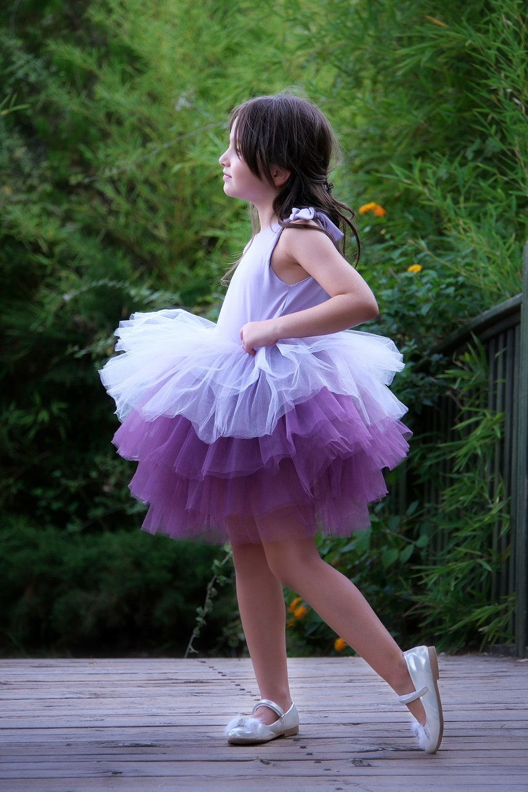 a little girl wearing a purple and white dress