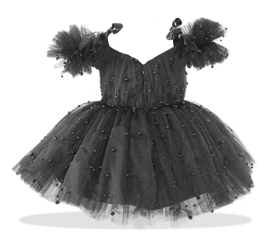 a little girl's black dress with pearls on it
