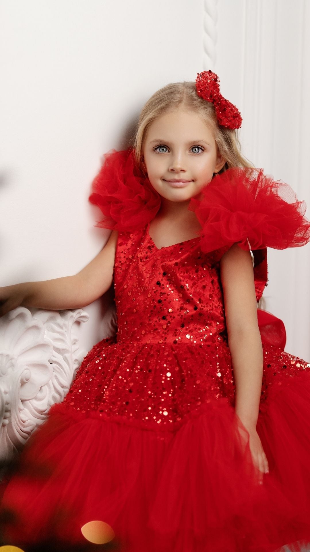 a little girl in a red dress sitting on a white chair Baby Girl Dress