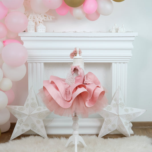 a baby girl's pink and white dress and star decorations