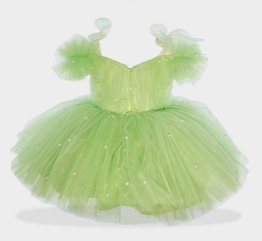 a little girl in a green dress on a white background