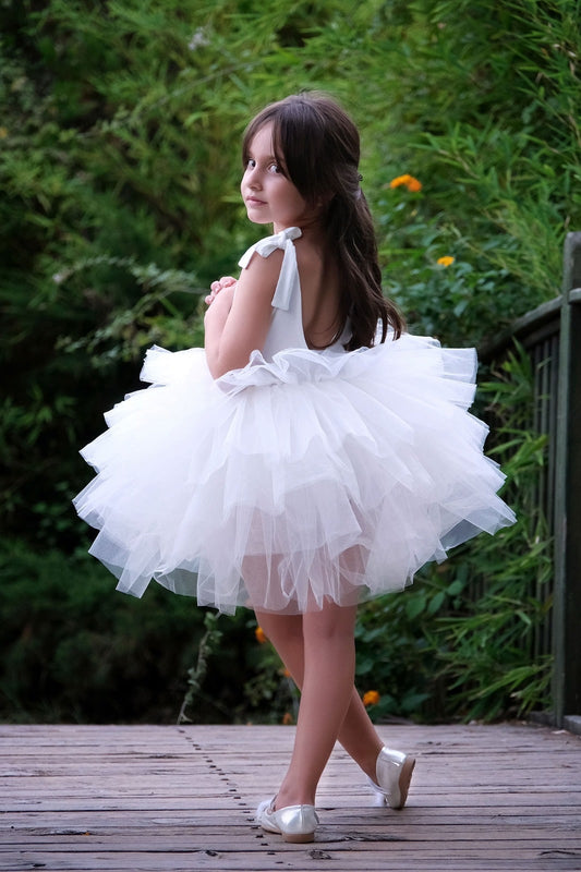 a little girl dressed in a white dress